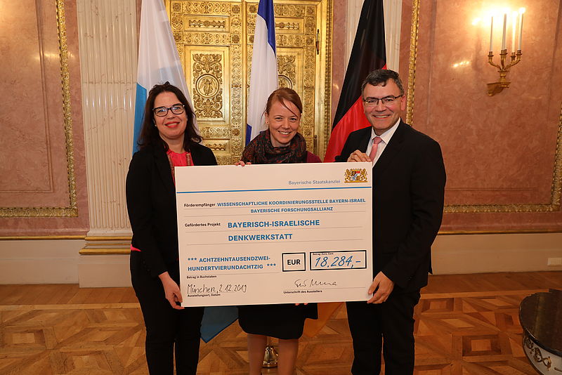 Europaminister Dr. Florian Herrmann, MdL (rechts) mit der israelischen Generalkonsulin Sandra Simovich (links) und Anna Abelmann-Brockmann (Mitte) von der Wissenschaftlichen Koordinierungsstelle Bayern-Israel der Bayerischen Forschungsallianz (BayFOR) bei der Übergabe des Förderbescheids.